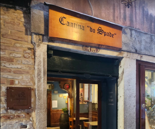 Exterior entrance and wooden sign of Cantina do Spade, a historic bacaro and wine bar in Venice, Italy.
