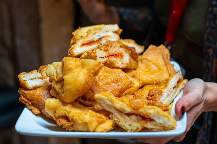 Close up of Mozzarella in Carrozza, a traditional fried Venetian cicchetto with melted cheese and prosciutto, served at Cantina Do Spade in Venice
